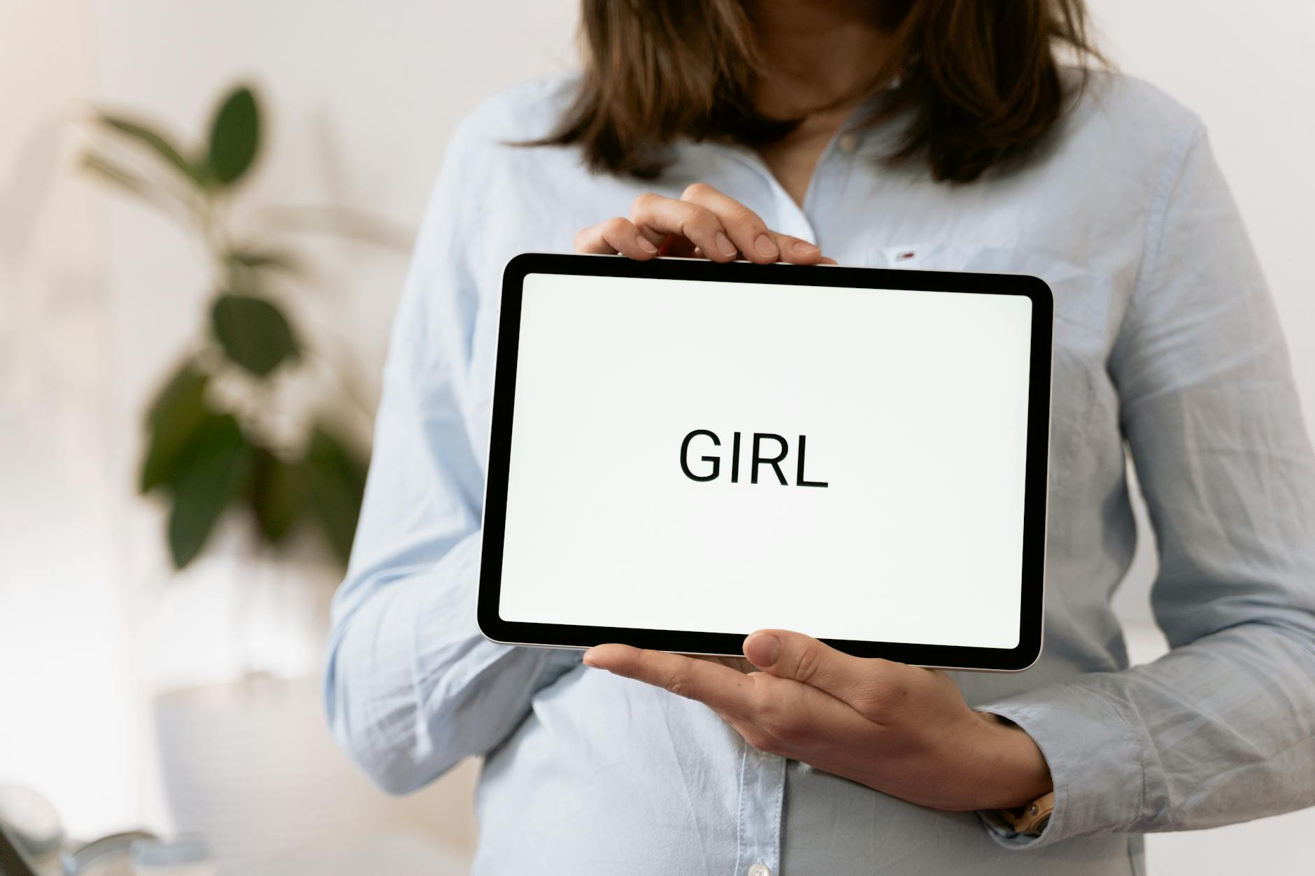 Ciężarna kobieta ogląda na tablecie wynik badania w gabinecie lekarza