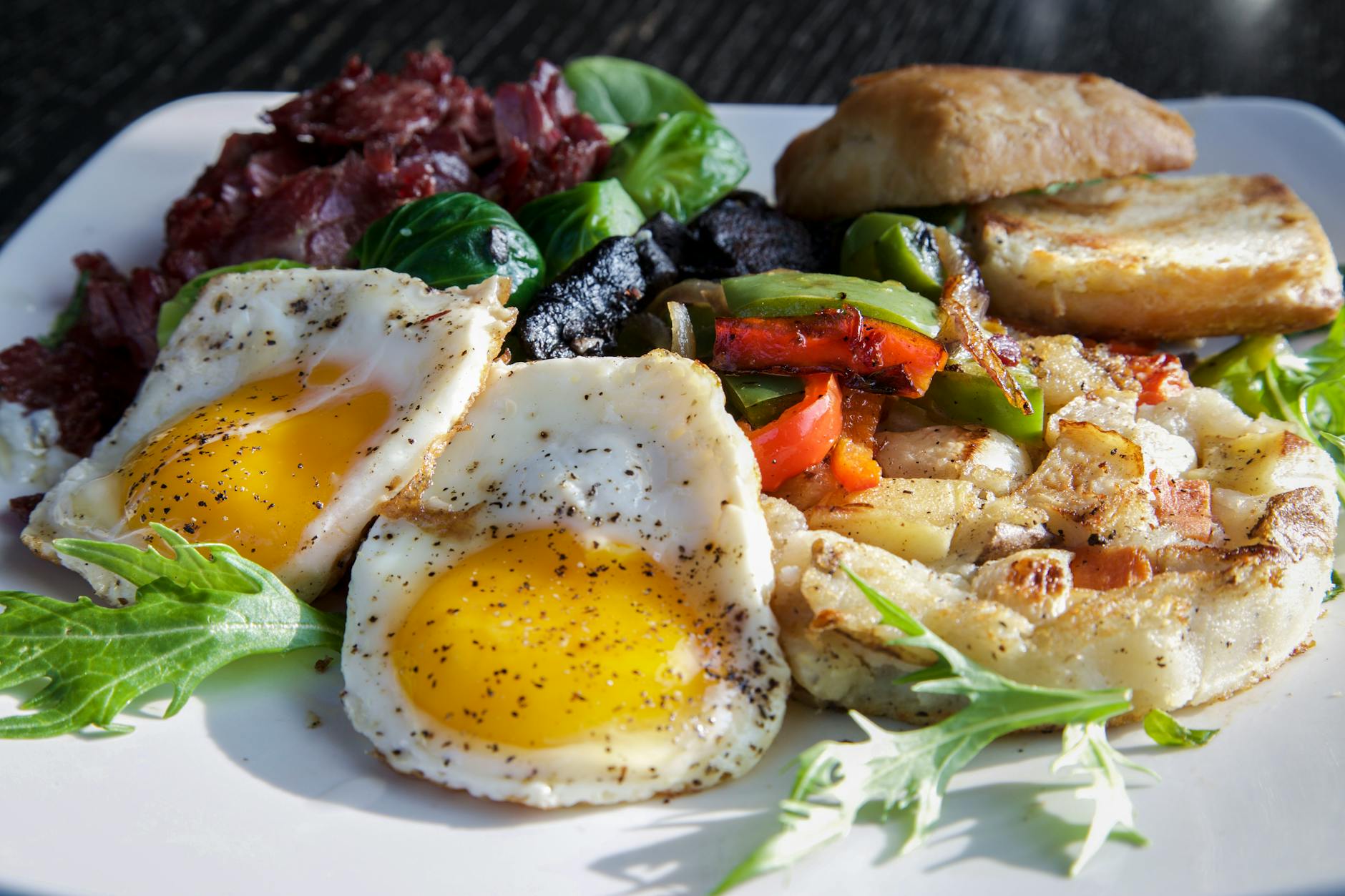 Talerz śniadaniowy z jajkami sadzonymi, warzywami i kromką pieczywa