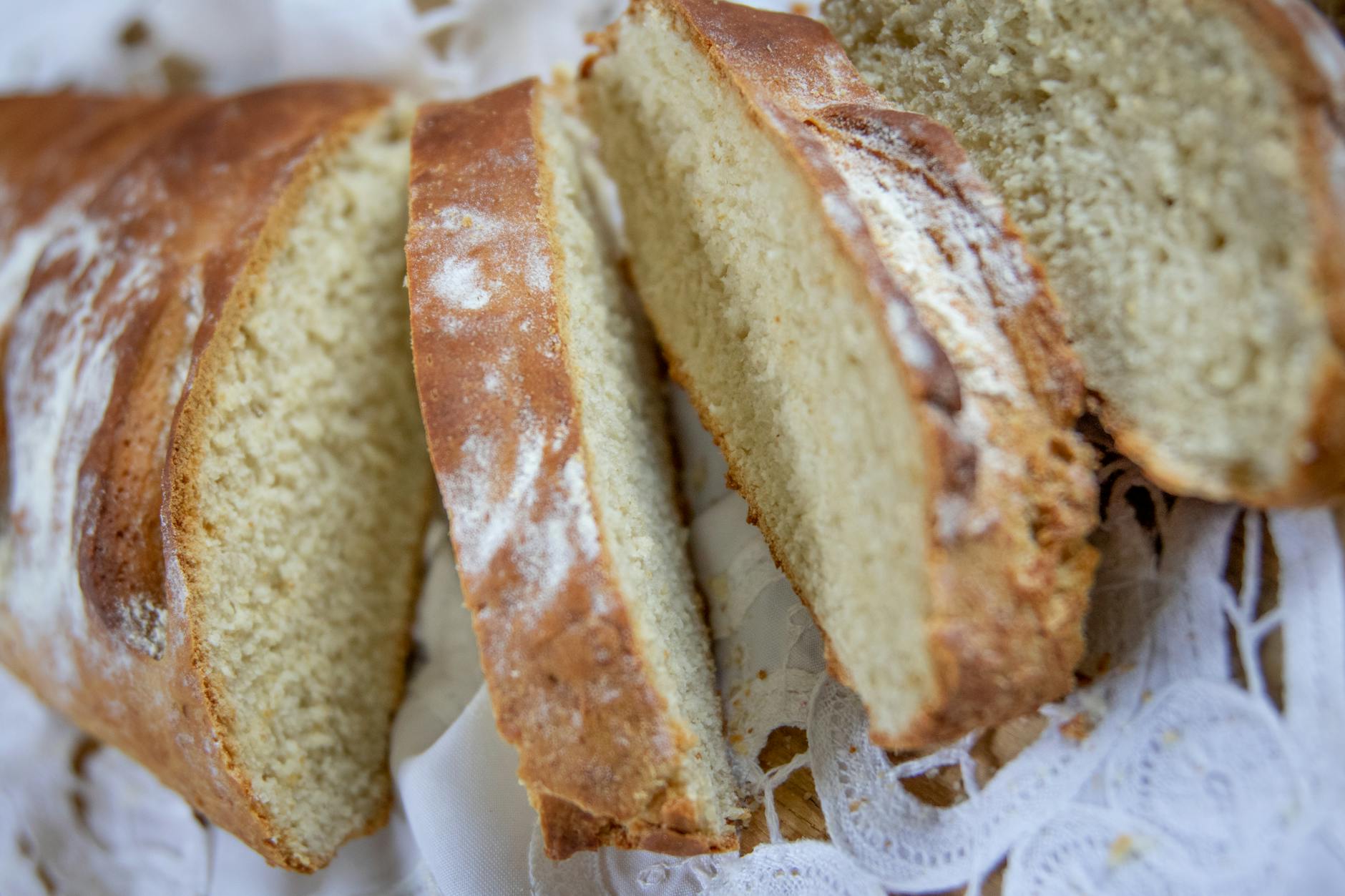 Kromki świeżo upieczonego chleba na koronkowej serwecie