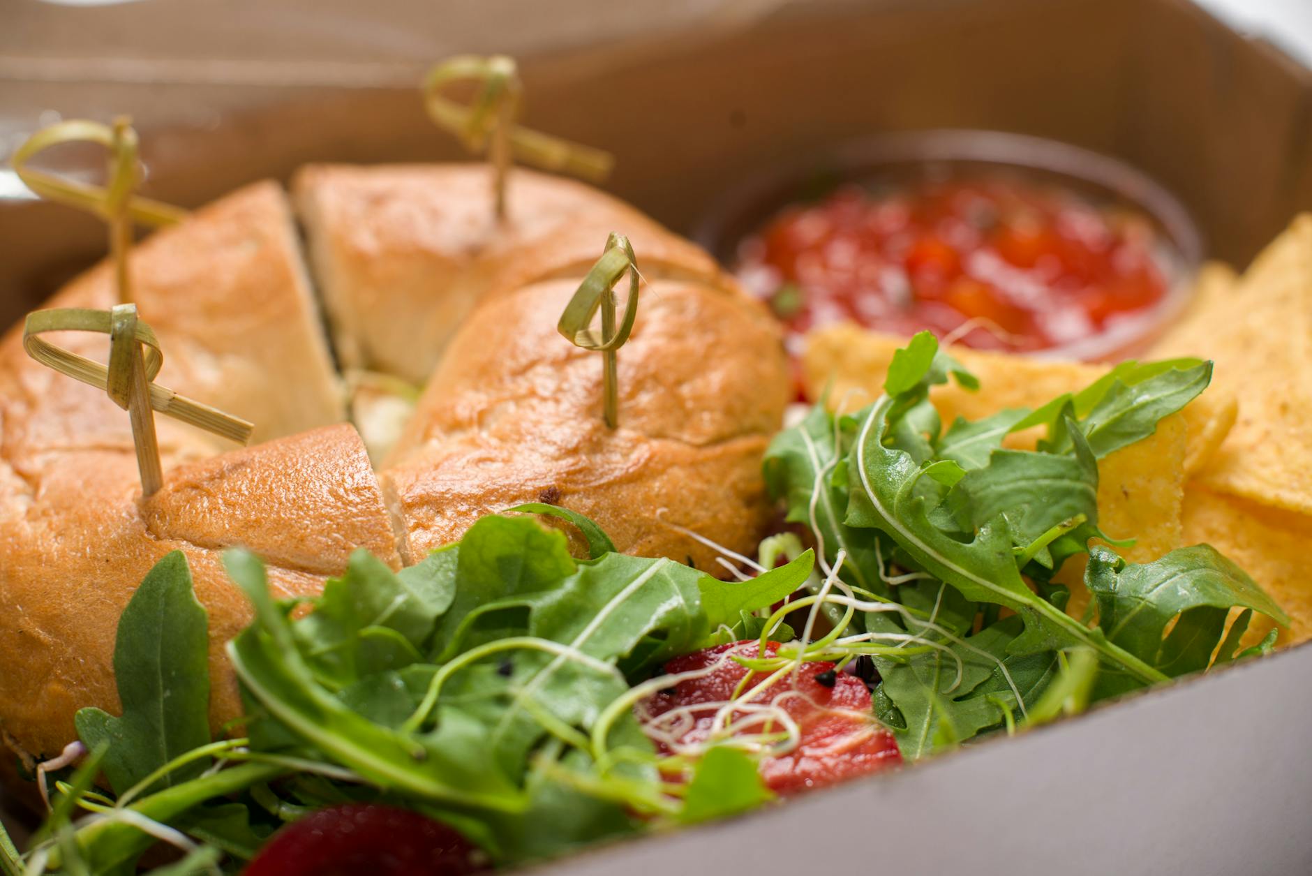 Lunchbox z bajglem, świeżą sałatą, chipsami i sosem