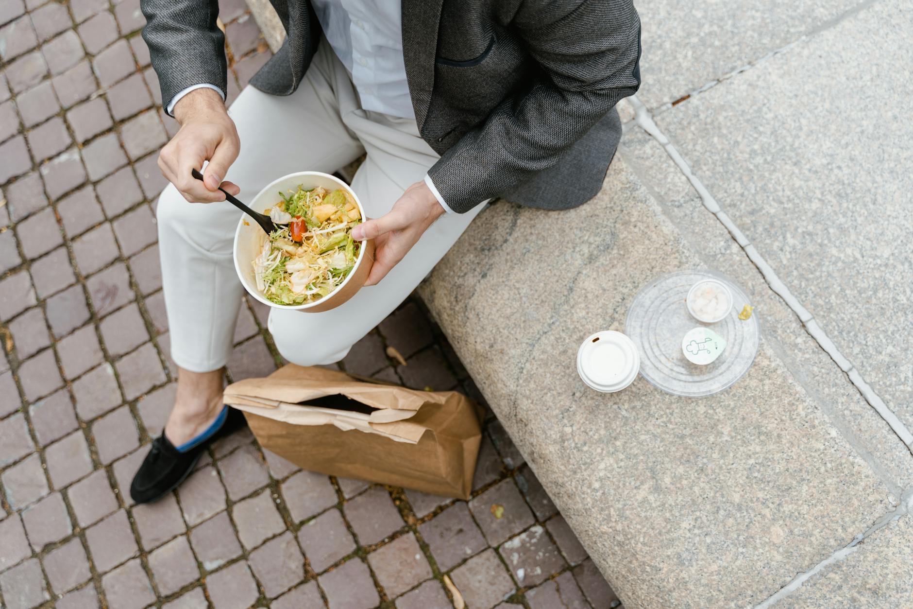 Osoba je sałatkę warzywną na zewnątrz w czasie miejskiej przerwy na lunch